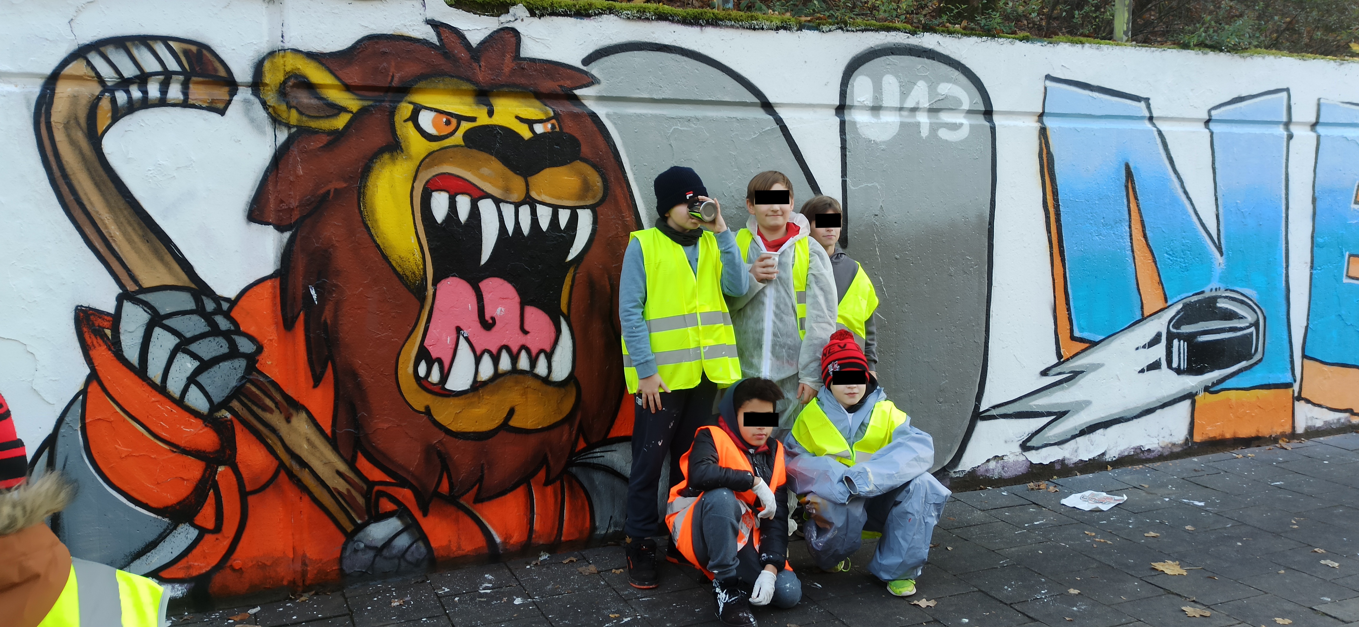 Große Gruppe vor einem gemeinsamen Graffiti-Mural