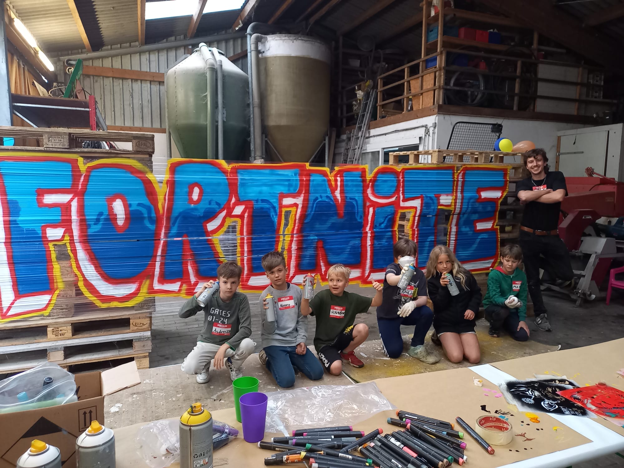 Gemeinsame kreative Session mit Spraydosen und Wandbild