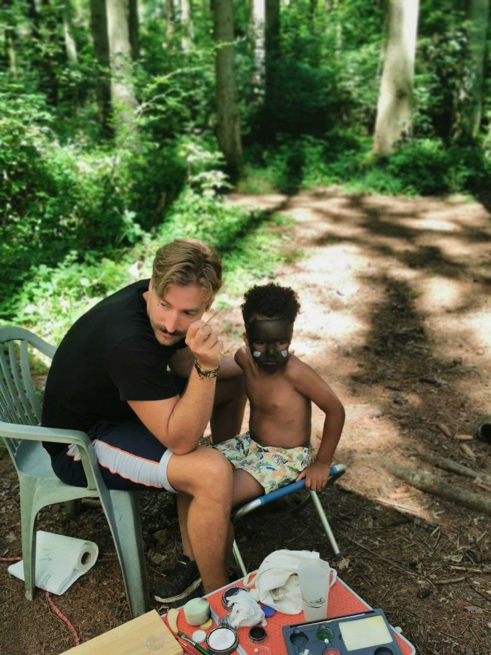 Luca und ein Kind freuen sich über das fertige Gesichtsmotiv